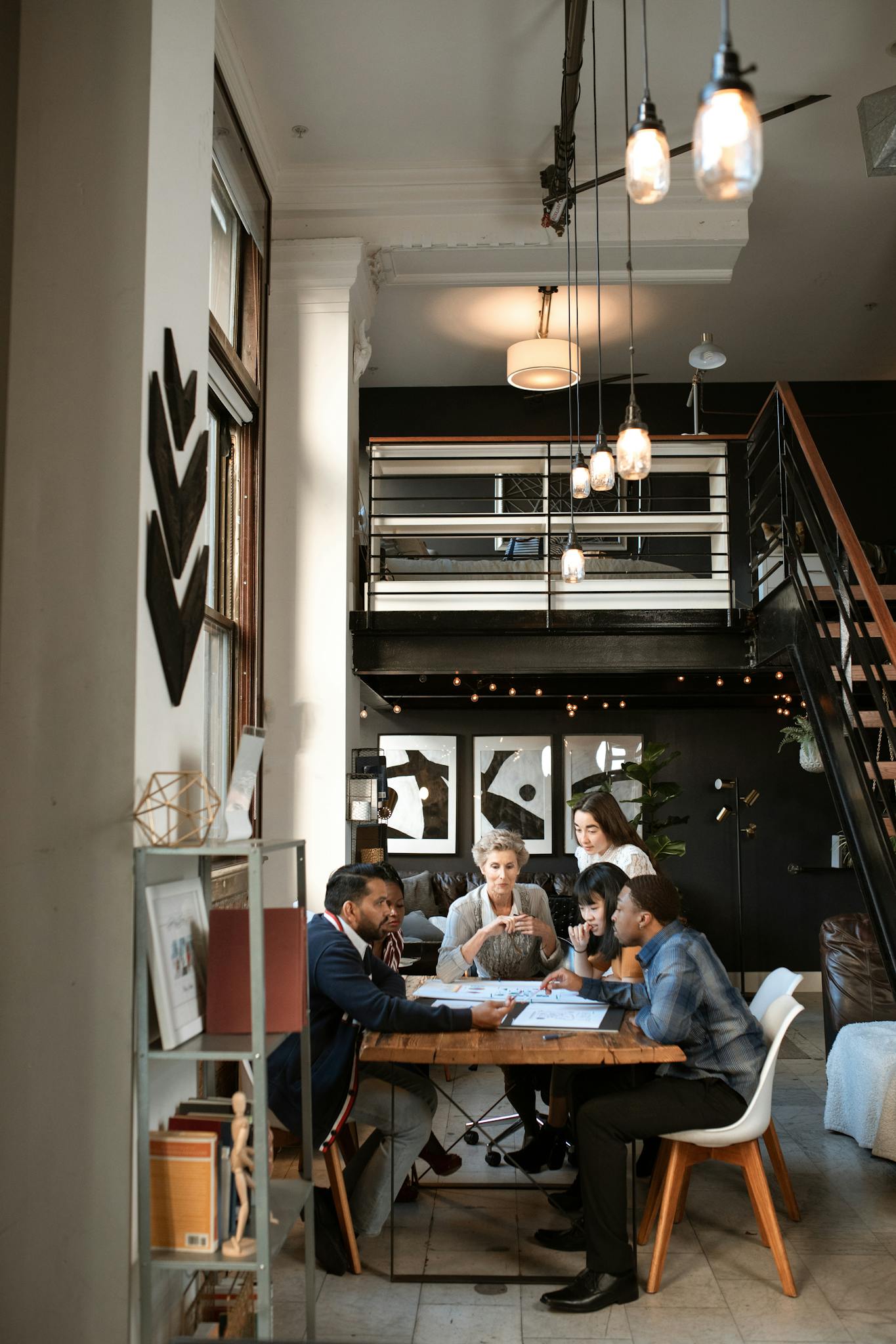 A diverse group of professionals collaborate in a stylish, modern coworking space with loft design.