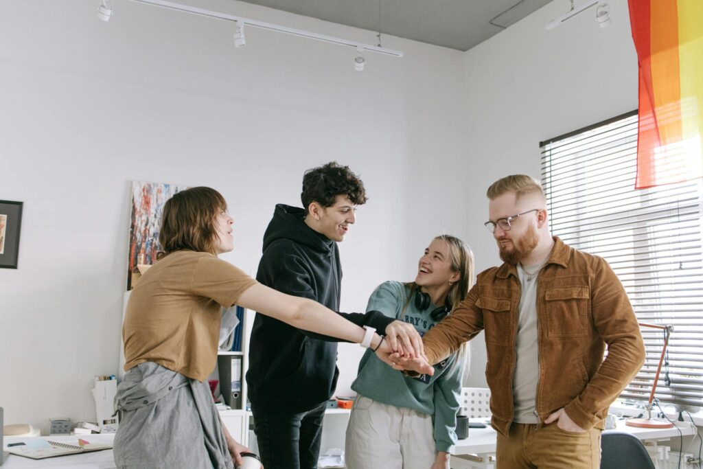 A group of colleagues engaging in team building with hands joined, expressing unity and camaraderie.