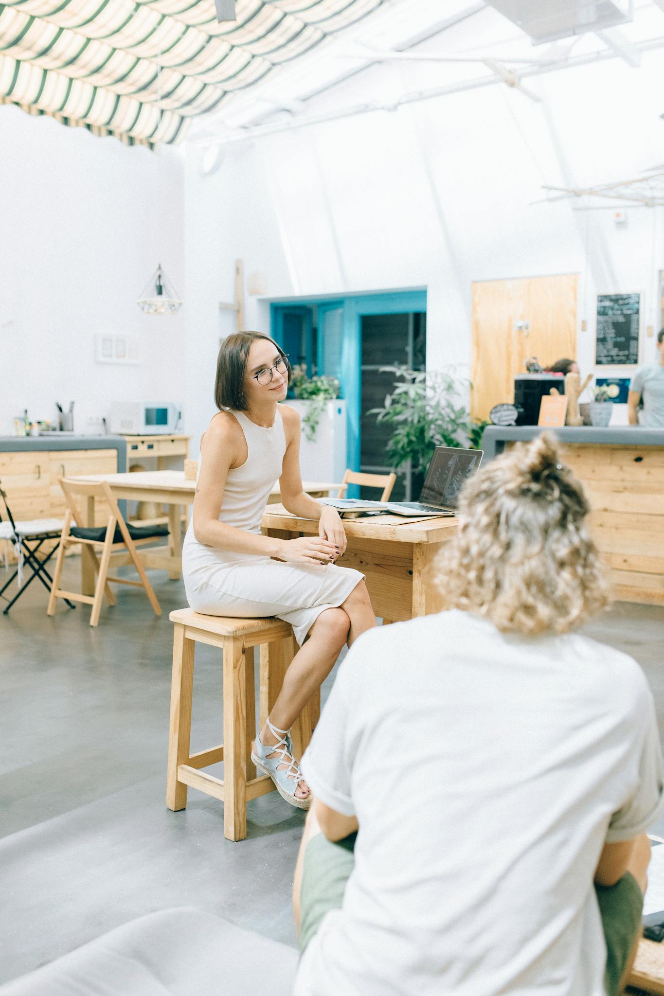 Casual conversation in a bright, modern coworking space emphasizes productivity and collaboration.